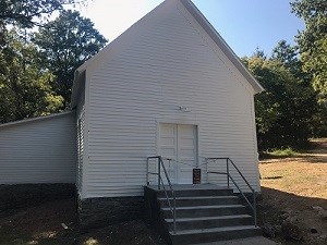 photo of white frame church with iron railing at front steps