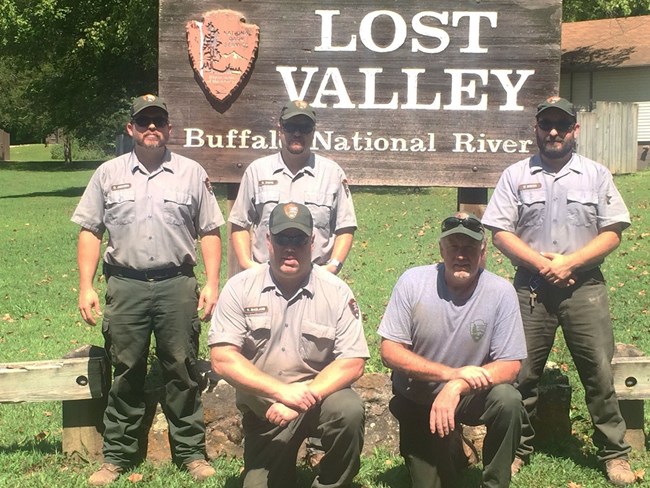 Five maintenance workers in front of Lost Valley sign Five maintenance workers in front of Lost Valley sign