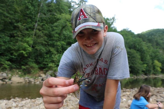 Child holding a crayfish