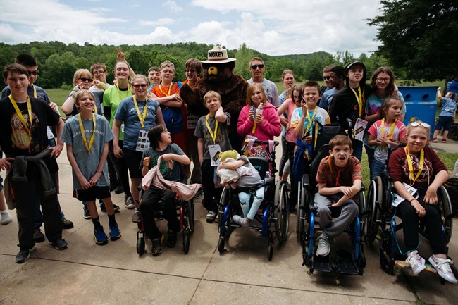 Special Olympics athletes smile for a group photo with Smokey Bear