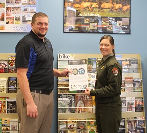 photo of Matt Bell and Ranger Casey Johannsen holding Centennial Iron Ranger Challenge poster