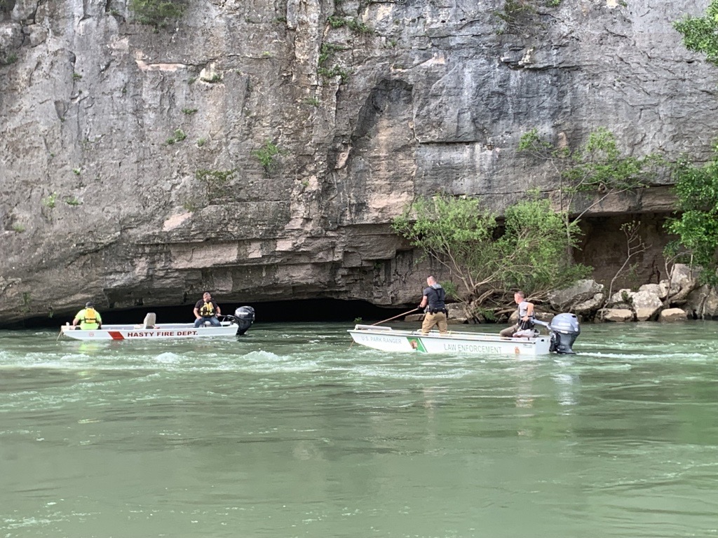 Rescue operations BUFF Color photo of 2 boats on a green river with rocks in the background.