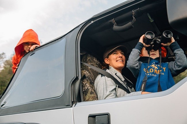 photo of people in car with binoculars