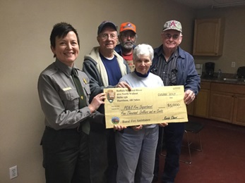 photo of five people holding large check