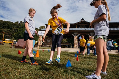 Students and Olympians participate in the long jump event.