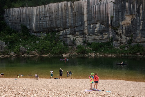 visitors along the shore of Buffalo NR with bluff in background