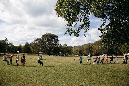 Kids and ranger play tug-o-war.