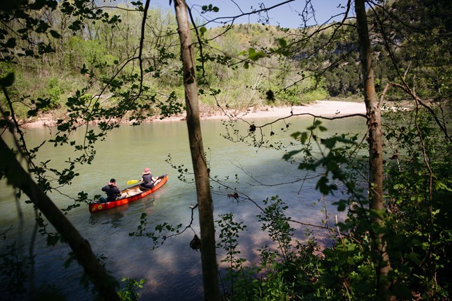Two paddlers in a canoe head downstream from Spring Creek.
