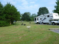color photo of campsite with 5th wheel trailer at right color photo of campsite with 5th wheel trailer at right