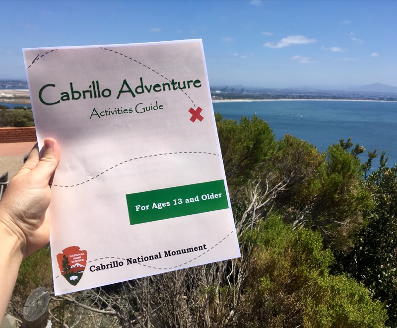 The 13 and older Cabrillo Adventure Activities Guide with the San Diego bay in the background.