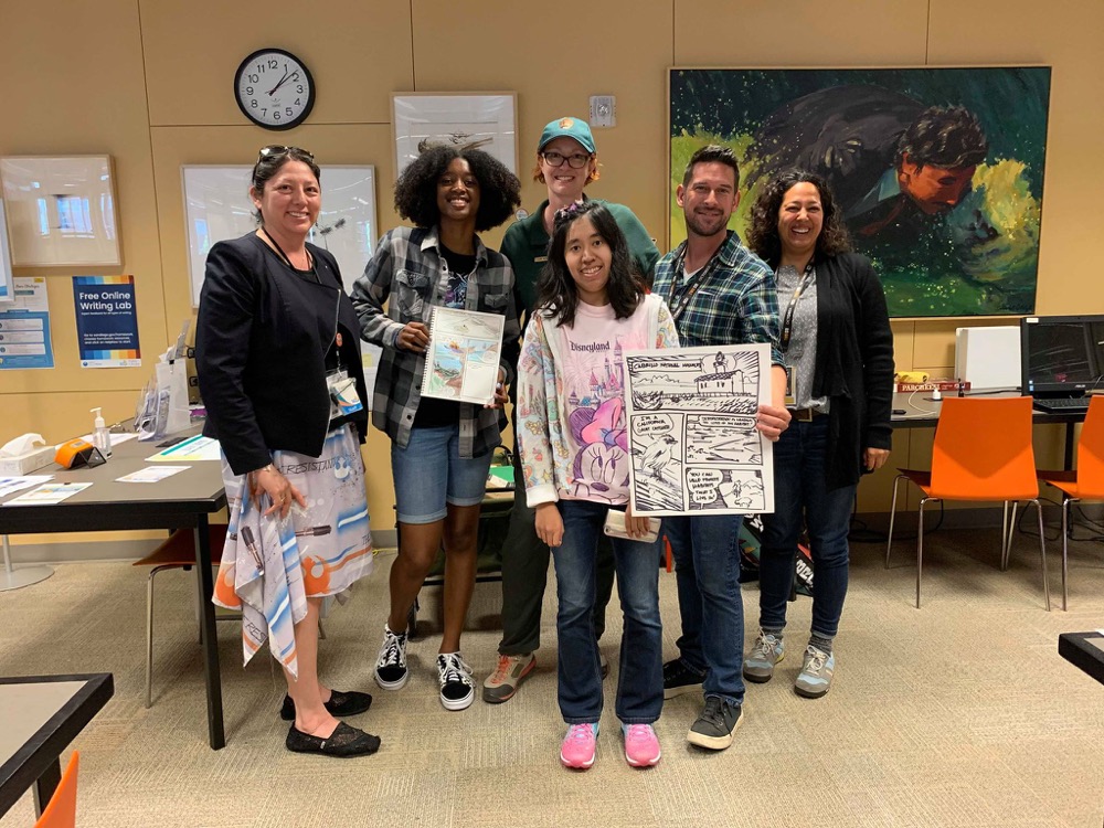 Depicted in this photograph (from left to right) is Catherine Hoang from SD Central Library, student Felix, instructor Samantha Wynns, instructor Alonso Nunez, graphic novelist Claudia Famosa, and student Krystal after a free Conservation+Comics workshop.
