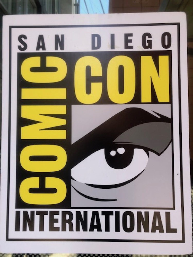 A shot of the San Diego Comic-Con International sign. This yellow, black, and grey graphic frames a close-up shot of a comic-book eye.