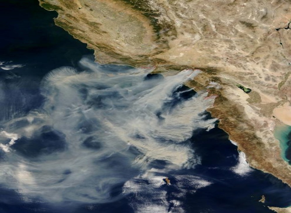 a satellite image of smoke being blown offshore from multiple fires burning in Southern California and Baja Mexico.