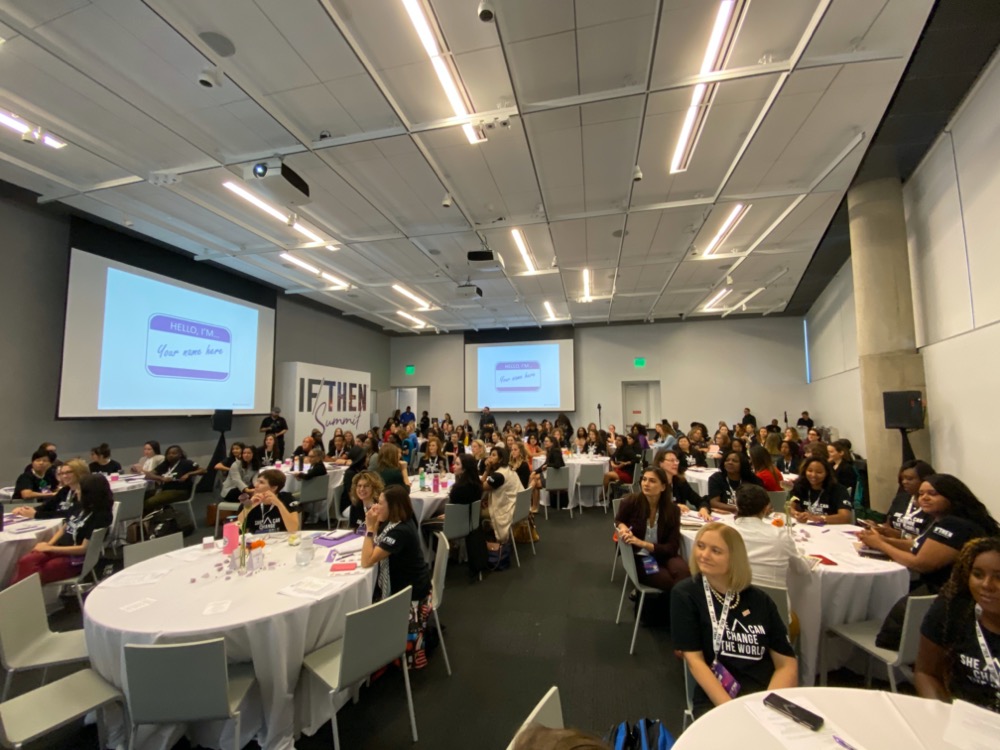A conference room filled with tables portraying the 125 IF/THEN® Ambassadors who sit at attention, ready for the science communication workshop during the summit.