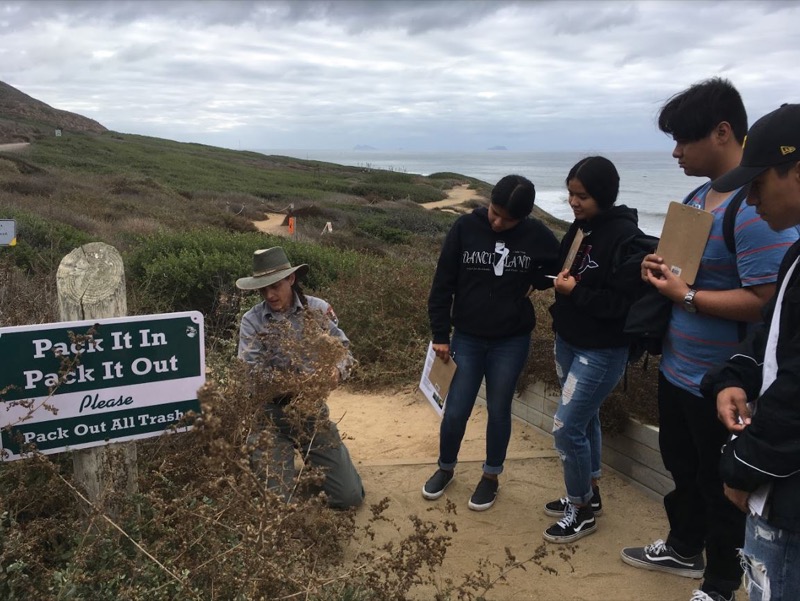 Ranger Lonie shows students differences between native and invasive plants