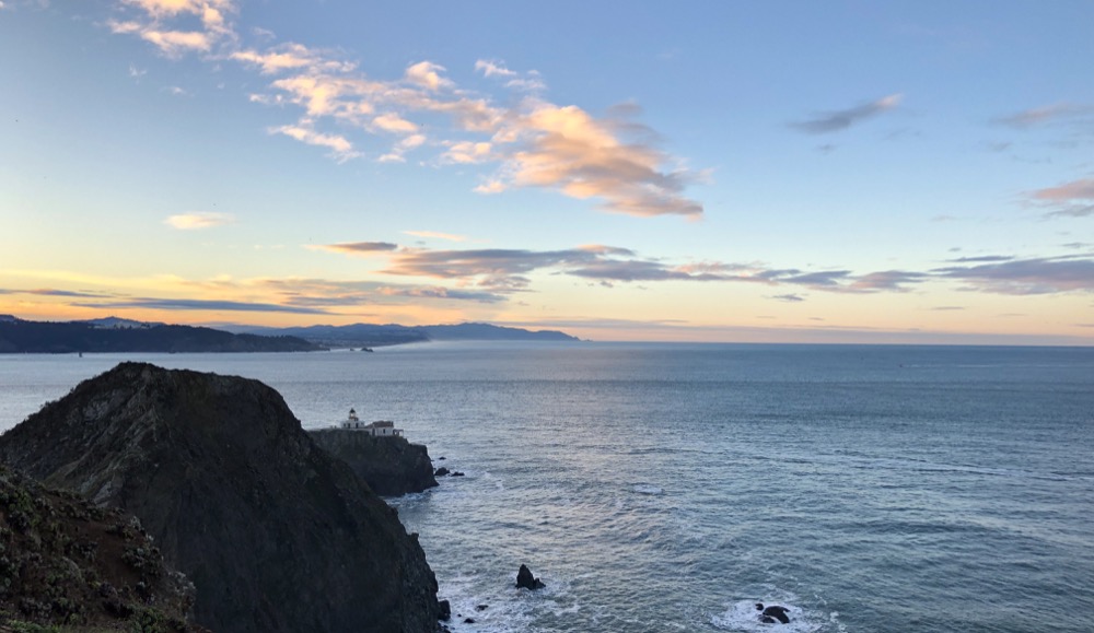Looking South across the mouth of the San Francisco Bay toward the Sunset District of West San Francisco, the Point Bonita Lighthouse sits on the tip of the Marin Headlands above the rugged cliffs.