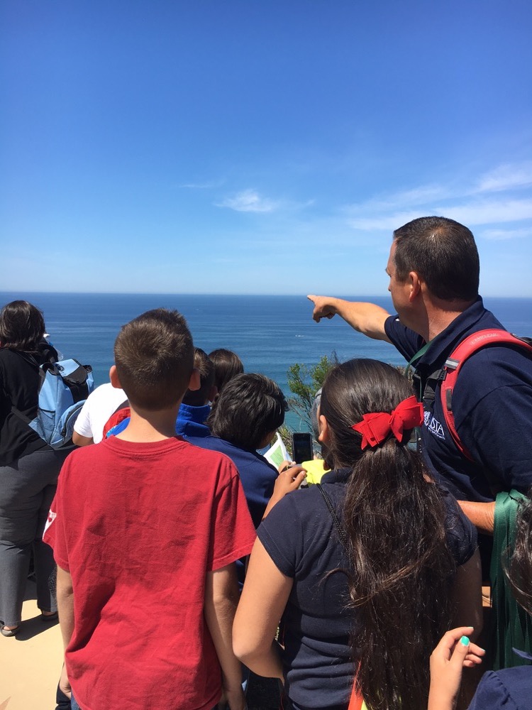 Mr. Andrew of the Science Education team points out biodiversity in the Pacific Ocean to a visiting class.