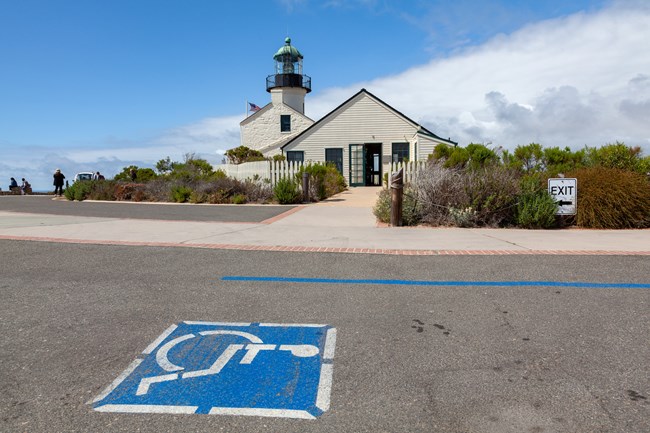 Blue and white accessible parking logo on street to south of the lighthouse.