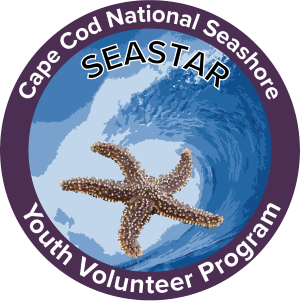 The SEASTAR Volunteer project logo. It is a circle with a purple border and a wave crashing over a starfish on the inside. There is text that reads "Cape Cod National Seashore SEASTAR Youth Volunteer Program."