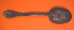A rusted spoon on a solid background.