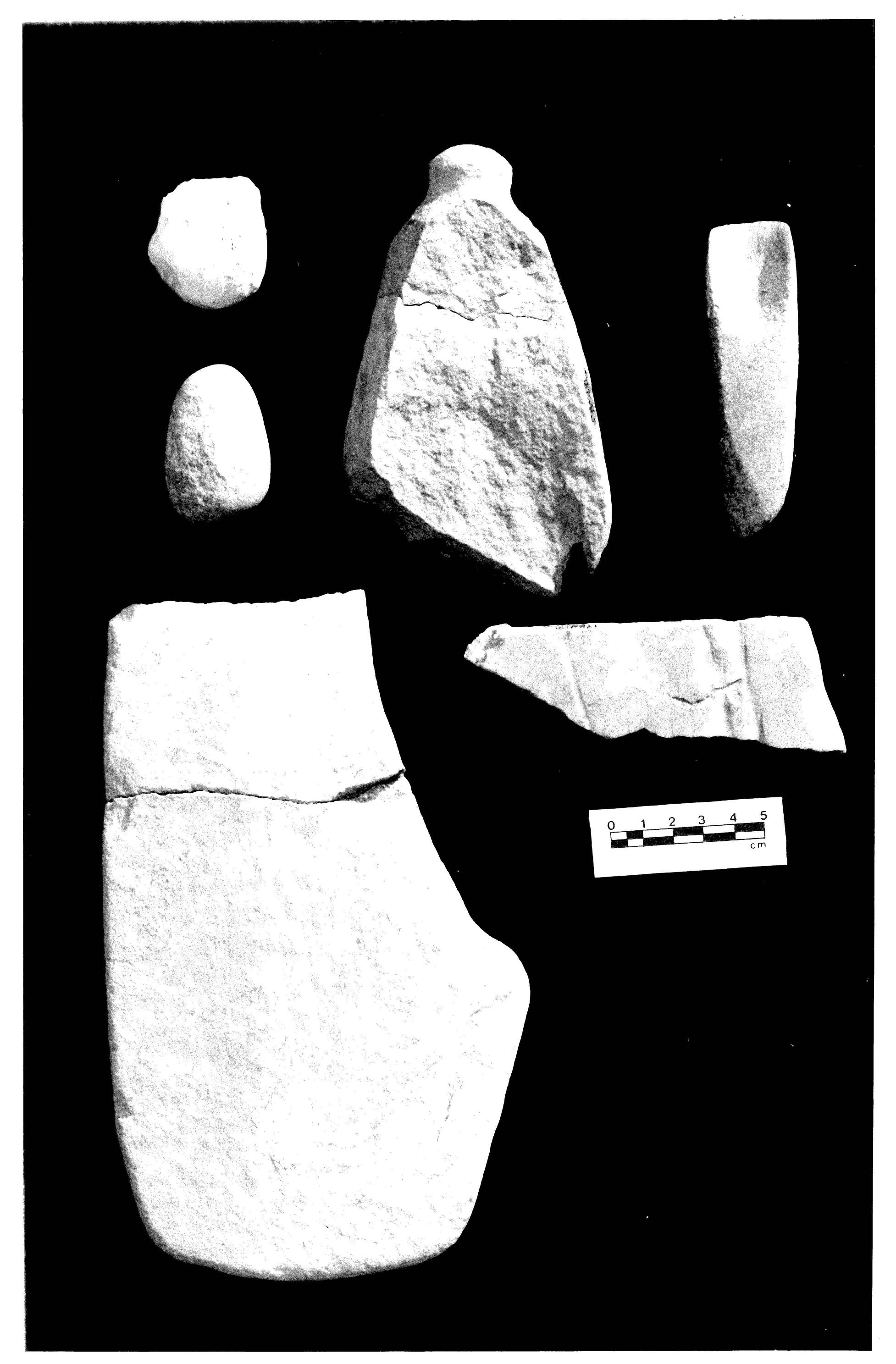 6 stone tools from an archaeological excavation are photographed in black and white.