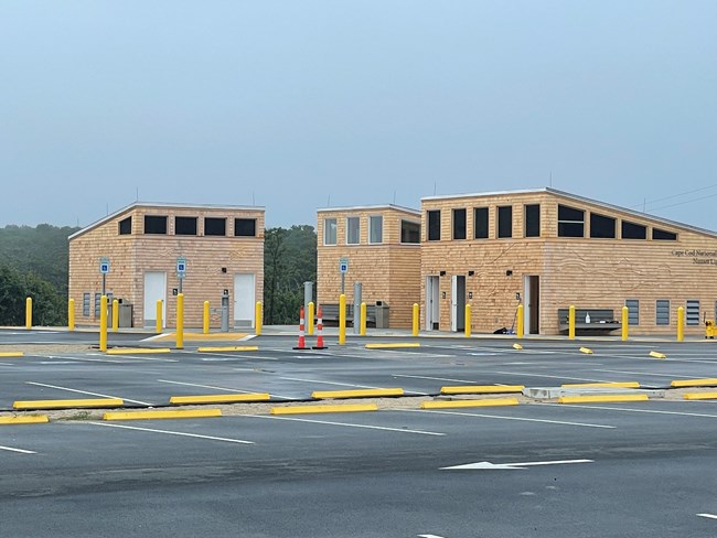 3 bathroom structures in a parking lot.