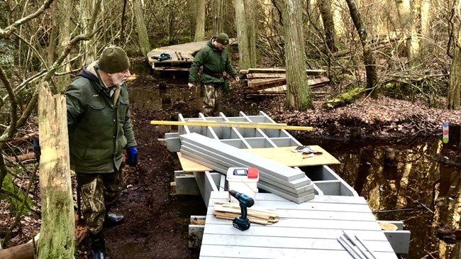 Maintenance staff rebuild sections of the swamp's boardwalk.