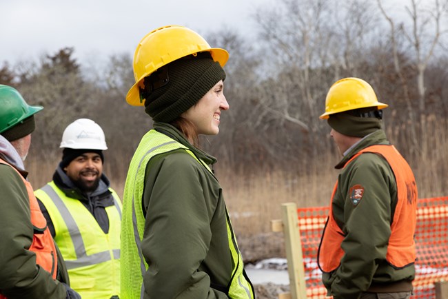 Woman in a hard hat smiles.