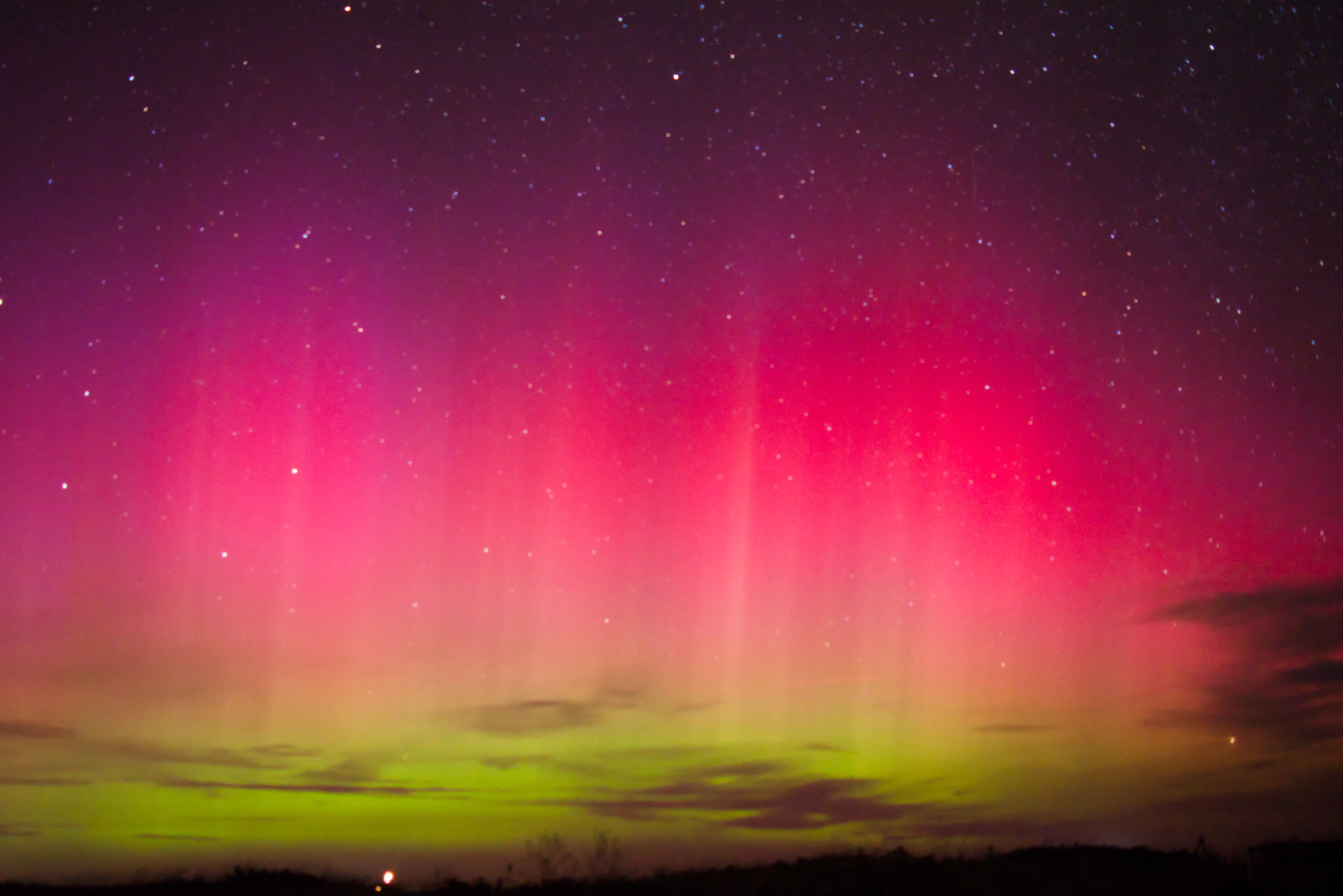 NorthernLightsAugust2024 Shades of purple, pink and green shimmering lights over a stary night landscape.