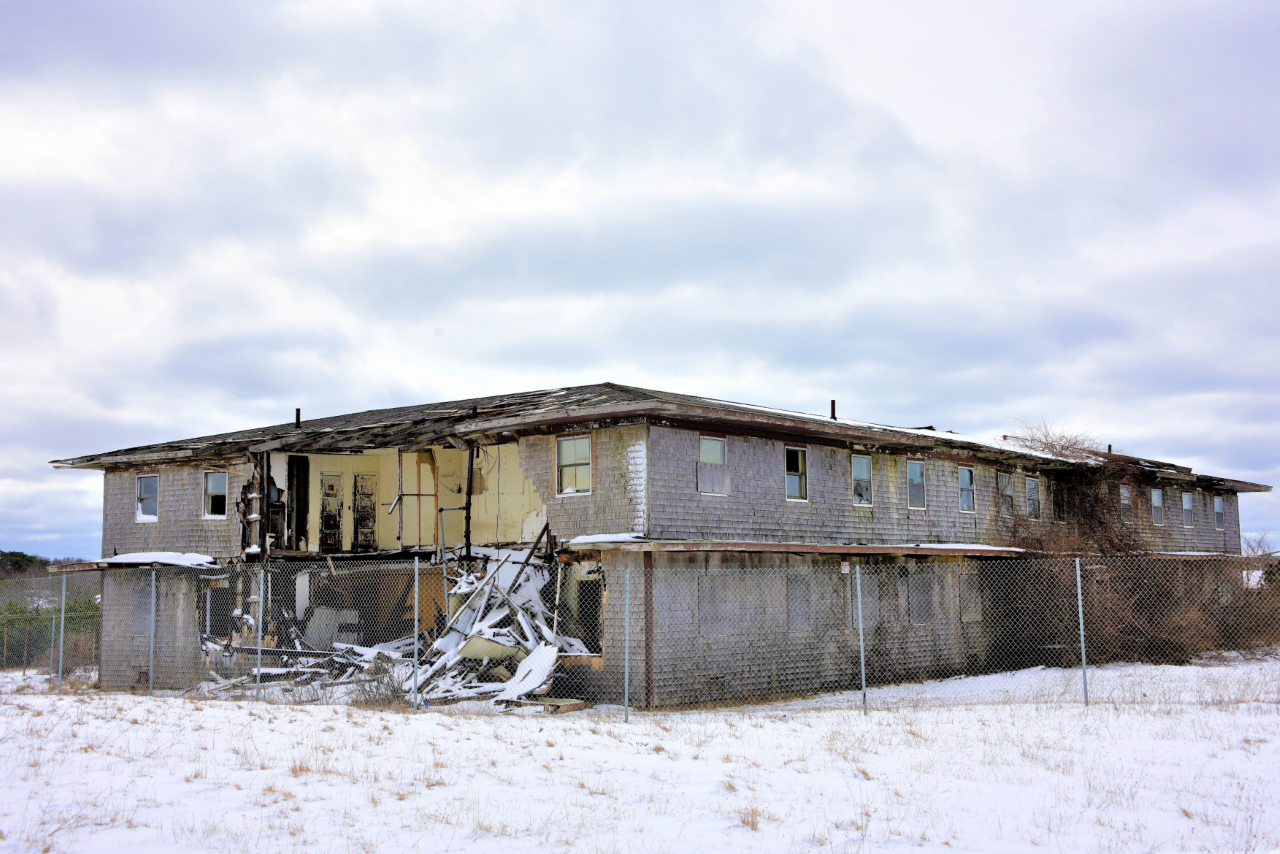GAOA Demo building A large building sits behind fencing with walls torn away, exposing the interior of the building.