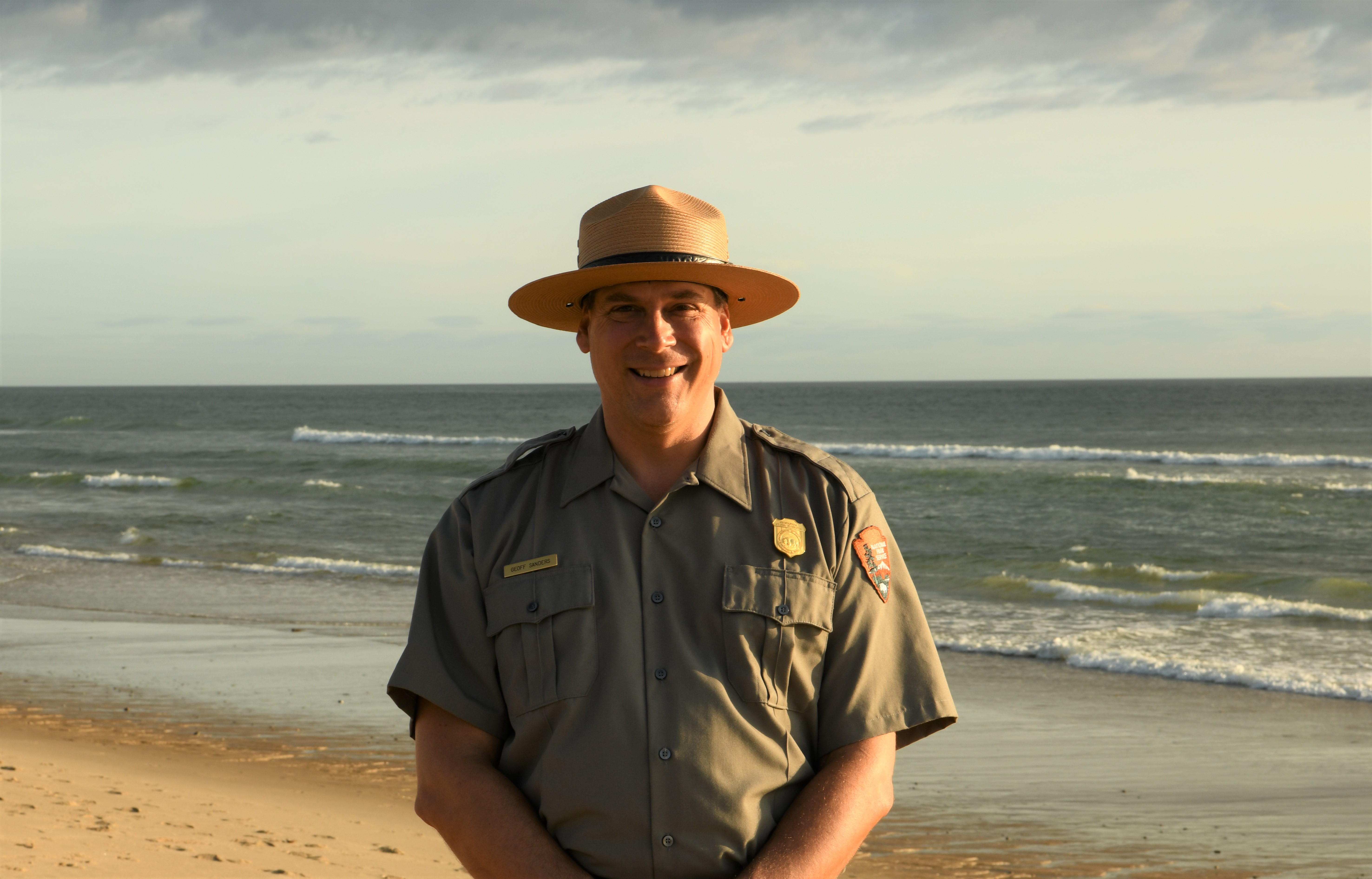 A ranger stands at the seashore