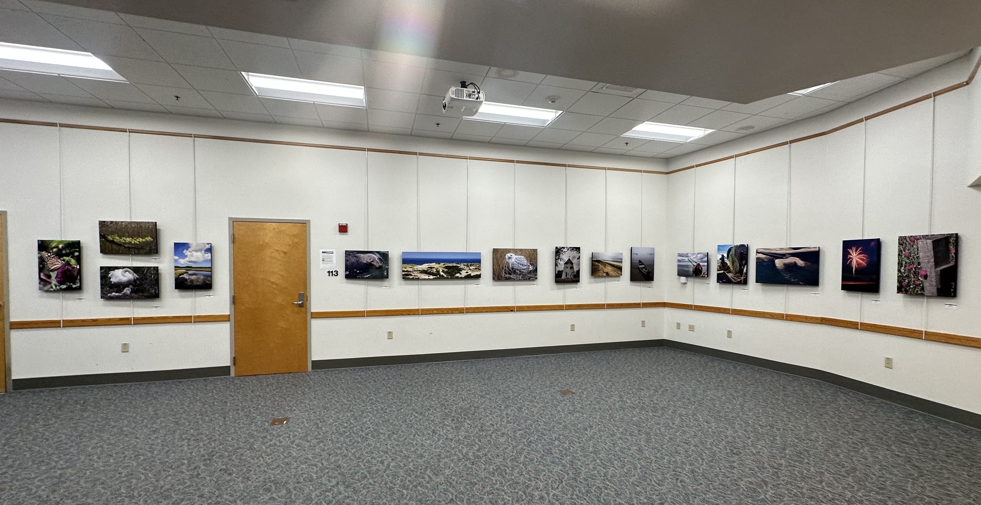 Salt Pond classroom art exhibit Art hung on a wall around a space in the visitor center.