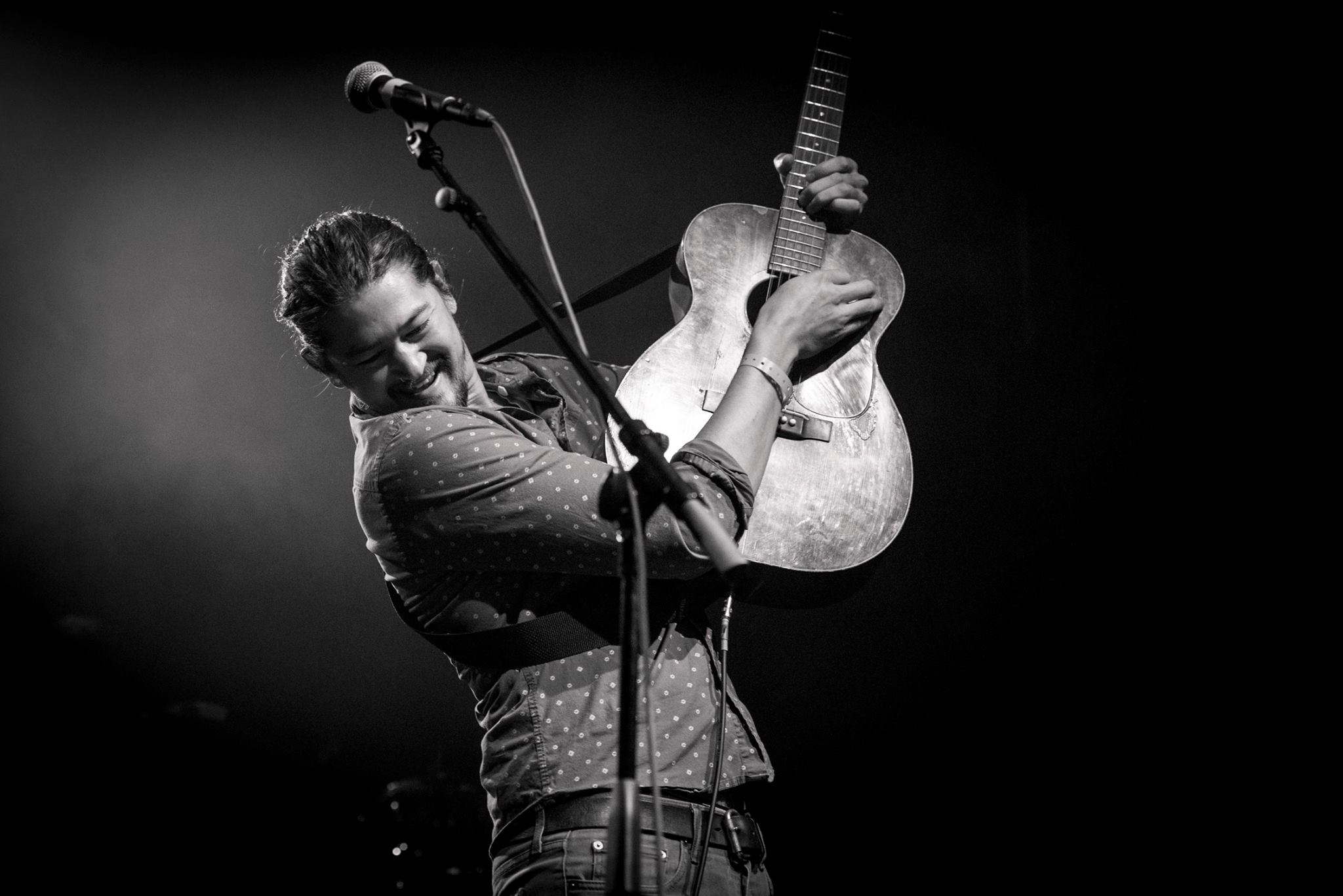 Artist Jay Psaros plays the guitar onstage.