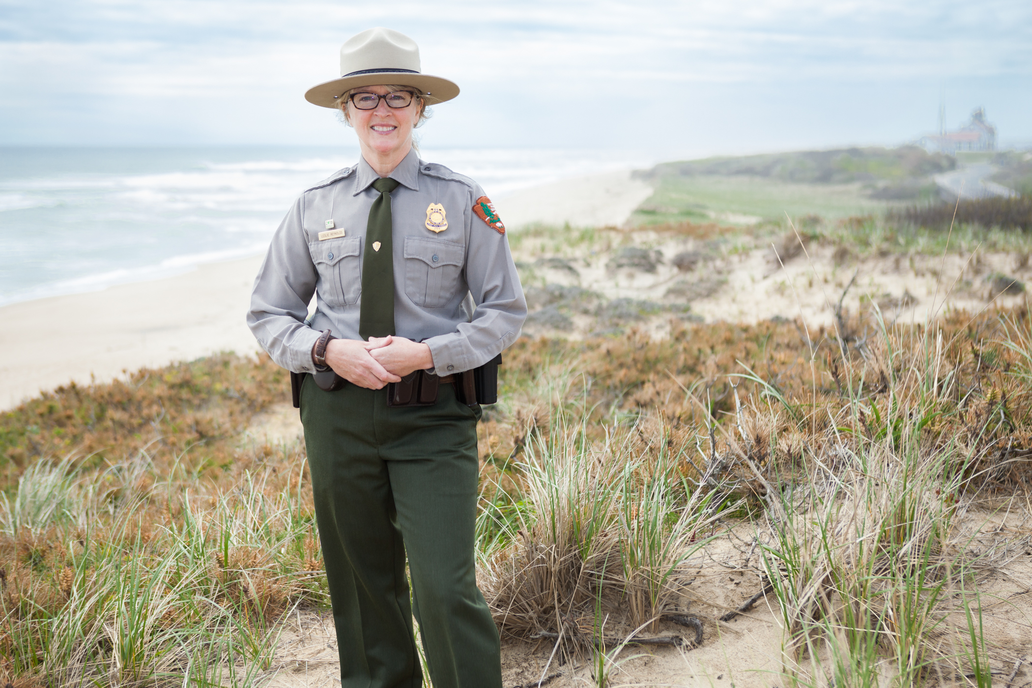 New Deputy Superintendent Leslie Reynolds Image of a woman in park ranger uniform standing near the beach