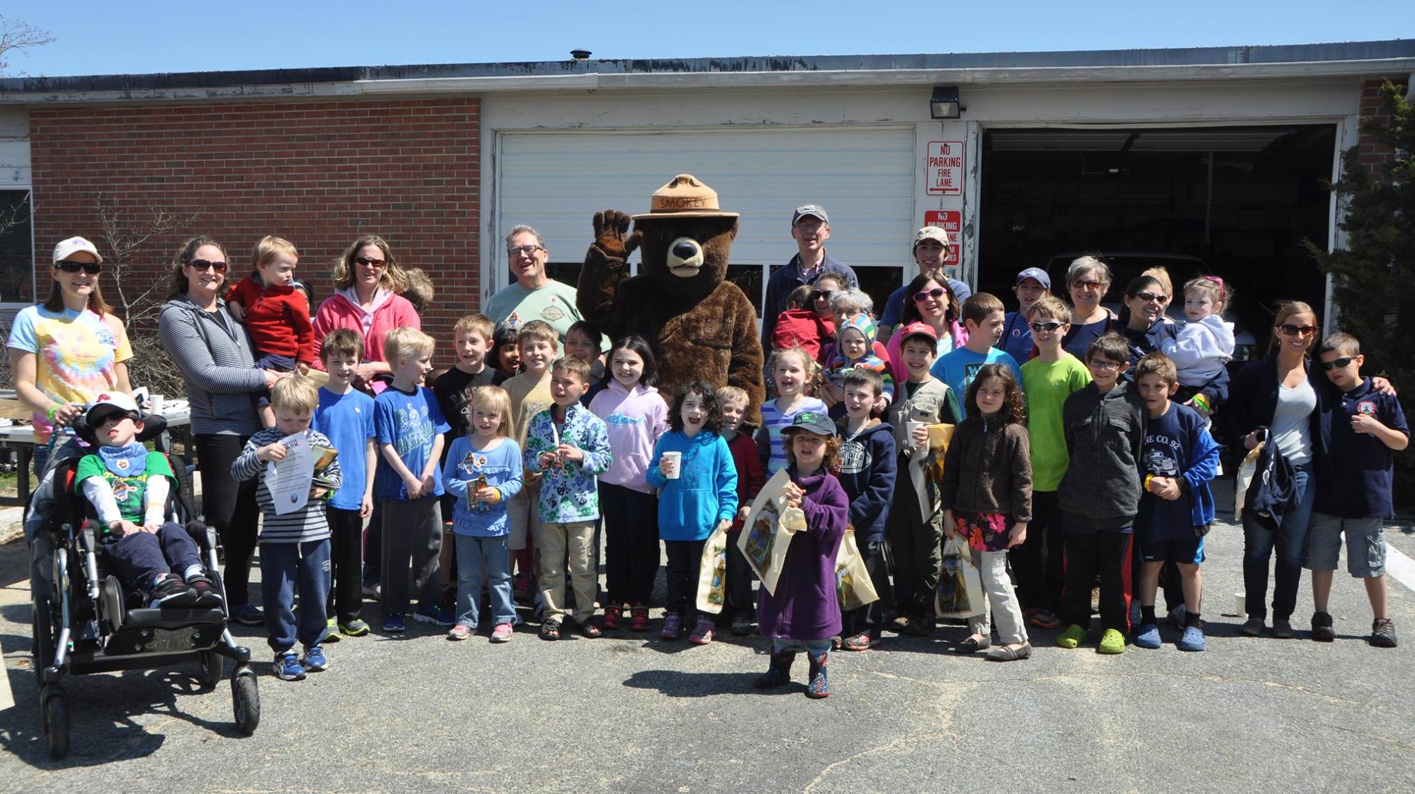 Smoky Bear surrounded by children