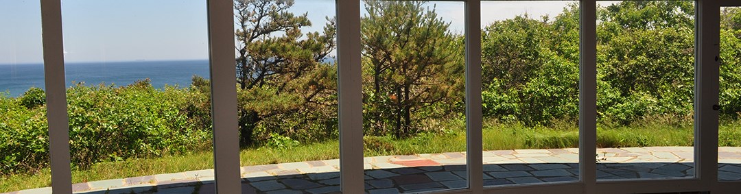 Looking out to sea through a wall of white framed full length windows. Looking out to sea through a wall of white framed full length windows.