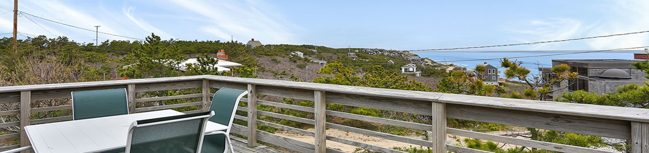 Looking across the deck of a wooden house out over the Atlantic Ocean.