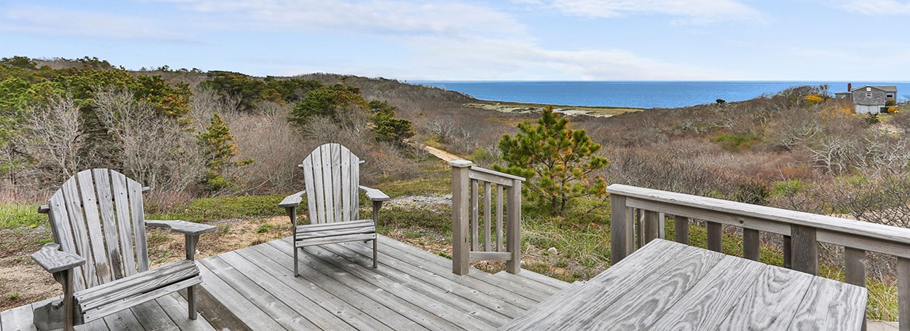 Wooden deck chairs look out over the ocean.