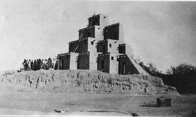 this black and white historical photograph shows the pageant's fake adobe building used as a backdrop for the play