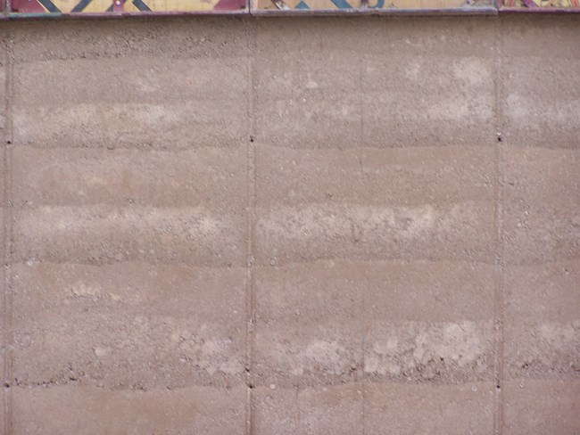 rammed earth wall close up shows layers in different shades of tan