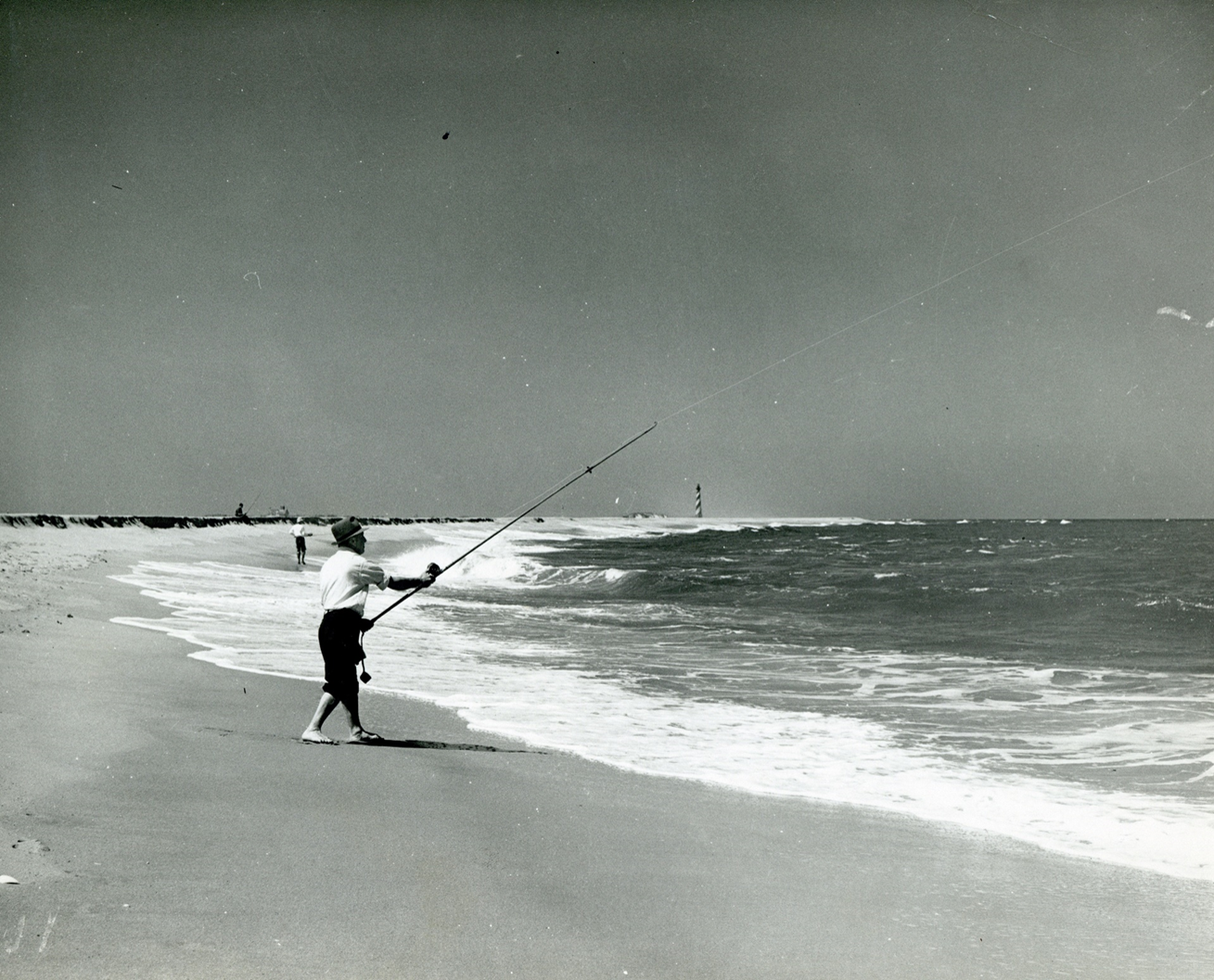 Cape Hatteras surf fishing with lighthouse in background.