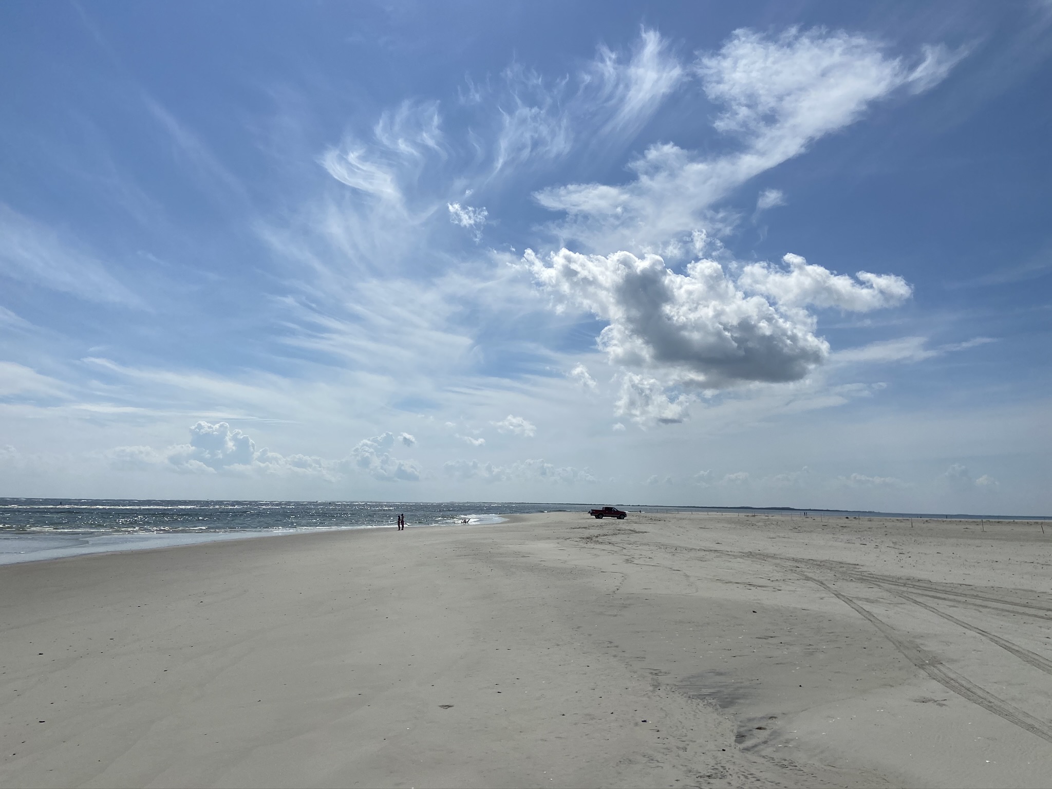 South Point on Ocracoke Island with one person and a vehicle in background.