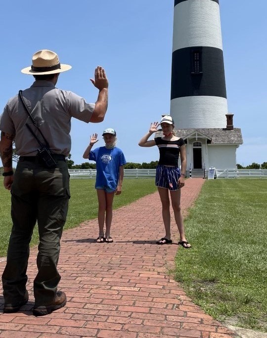 Two children taking the Junior Ranger oath from a ranger