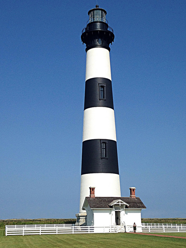 Bodie Island Lighthouse Park Ranger standing in front of Bodie Island Lighthouse.