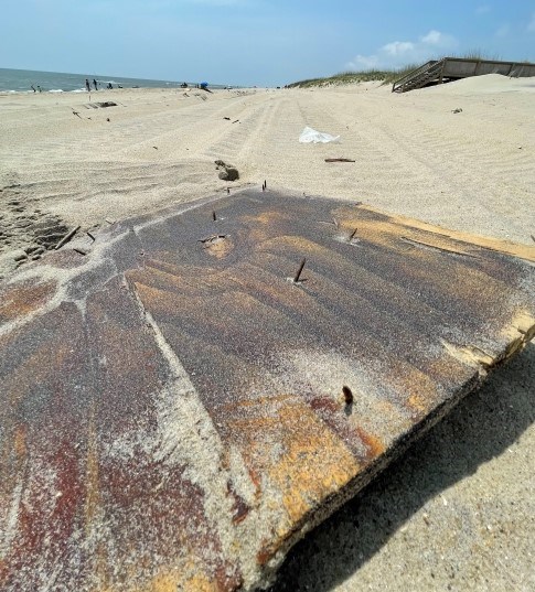 Large slab of wood containing exposed nails.