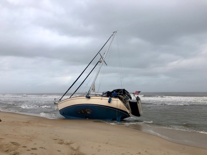 Sailing vessel on its side with ocean in background.