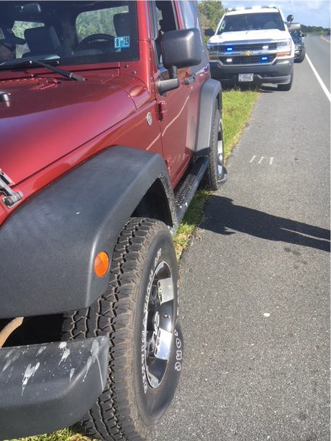 Red Jeep Wrangler with punctured tires.