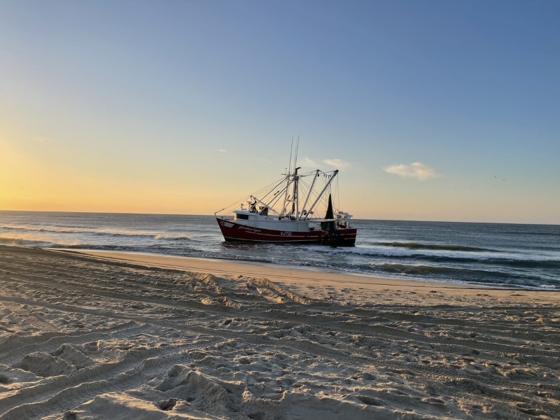 Jonathan Ryan grounding 11-29-2021 Grounded red and white vessel near beach.