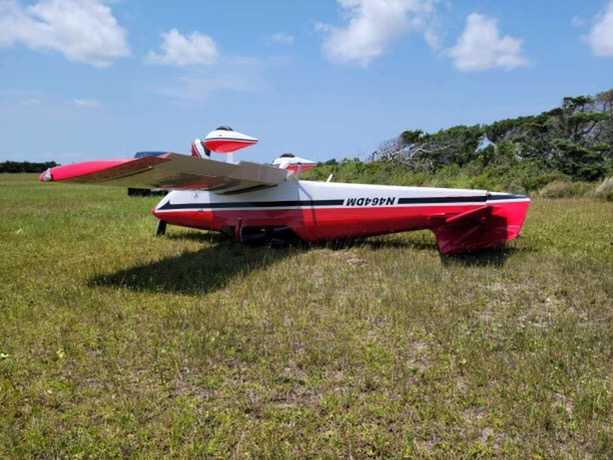 Photo of airplane on its roof on grass.