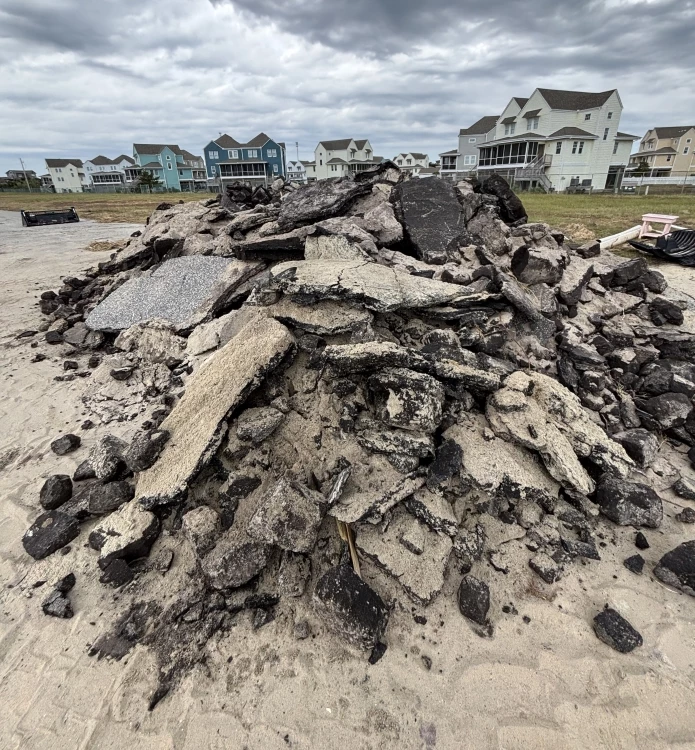 Photo of a portion of the concrete and asphalt collected by Seashore staff at Buxton Beach Access. Photo showing light gray and black colored concrete and asphalt in a pile ready to be removed.